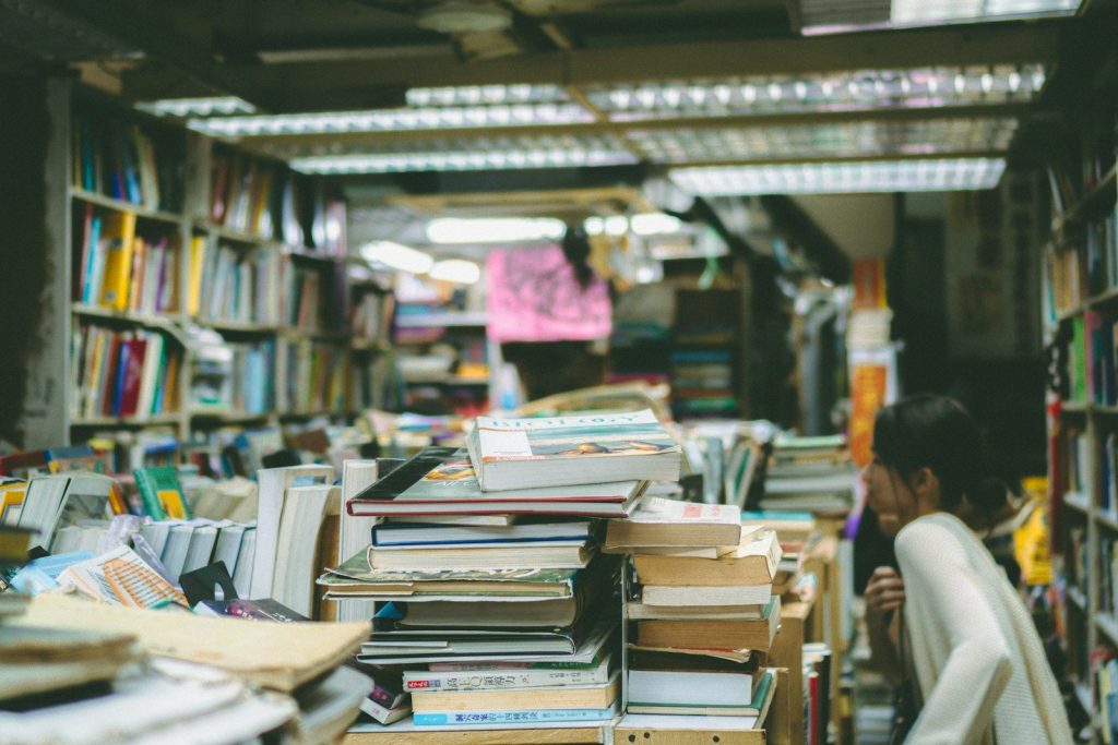 A person browsing books in a crowded bookstore.