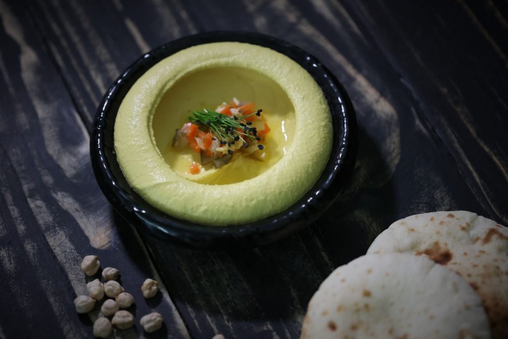 Close-up of creamy hummus served with pita bread, showcasing Middle Eastern cuisine.