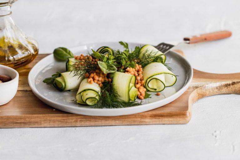 Delicious zucchini and lentil salad garnished with herbs on a wooden board, perfect for healthy eating.