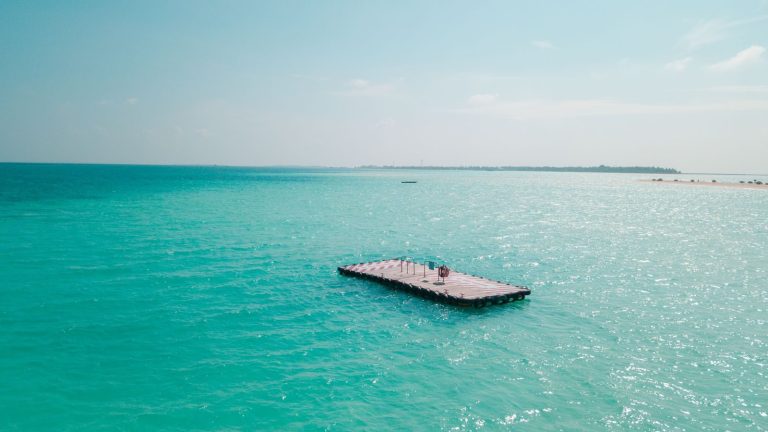 A serene floating platform amidst the vibrant turquoise sea of Maldives, ideal for summer relaxation.