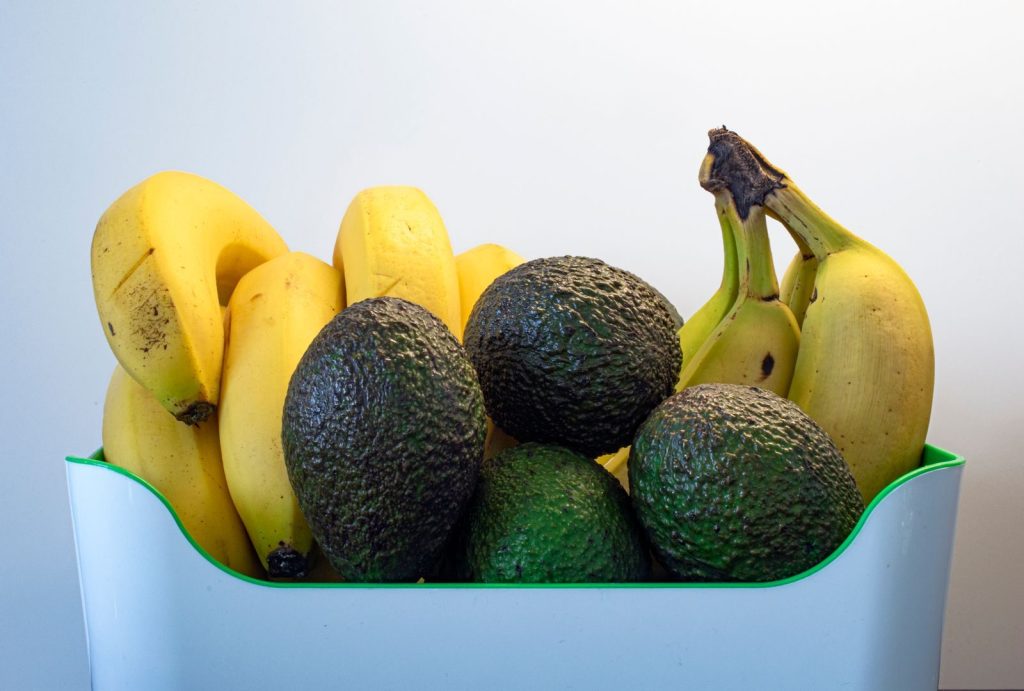 A close-up of ripe avocados and bananas arranged in a basket, perfect for healthy eating.