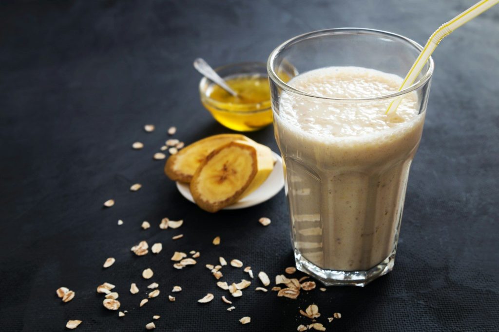 A glass of milk with a spoon next to it