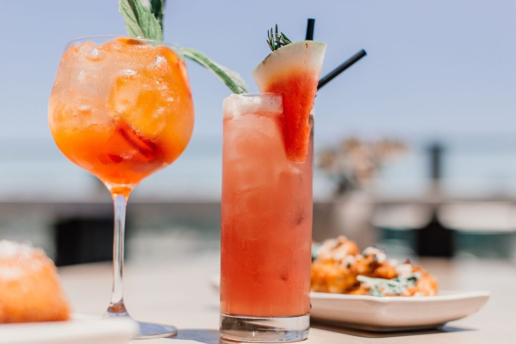 Chilled summer cocktails with fresh watermelon garnish, perfect for outdoor refreshment.
