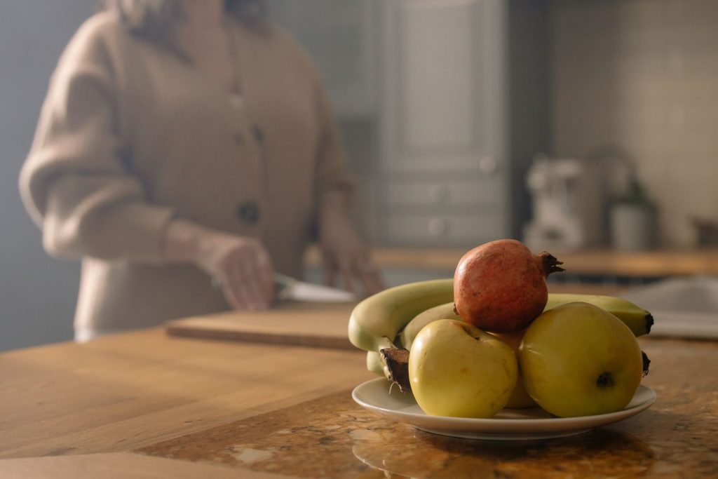 A close-up of fresh fruits on a plate in a cozy kitchen, perfect for healthy diet concepts.