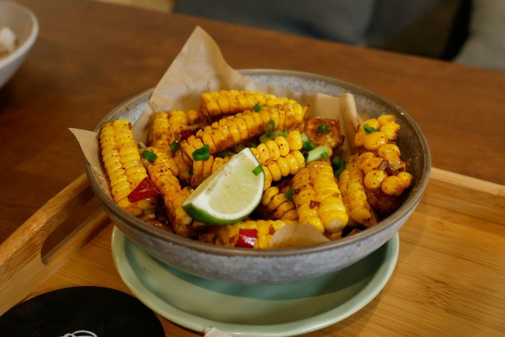 Bowl of seasoned corn on the cob with lime