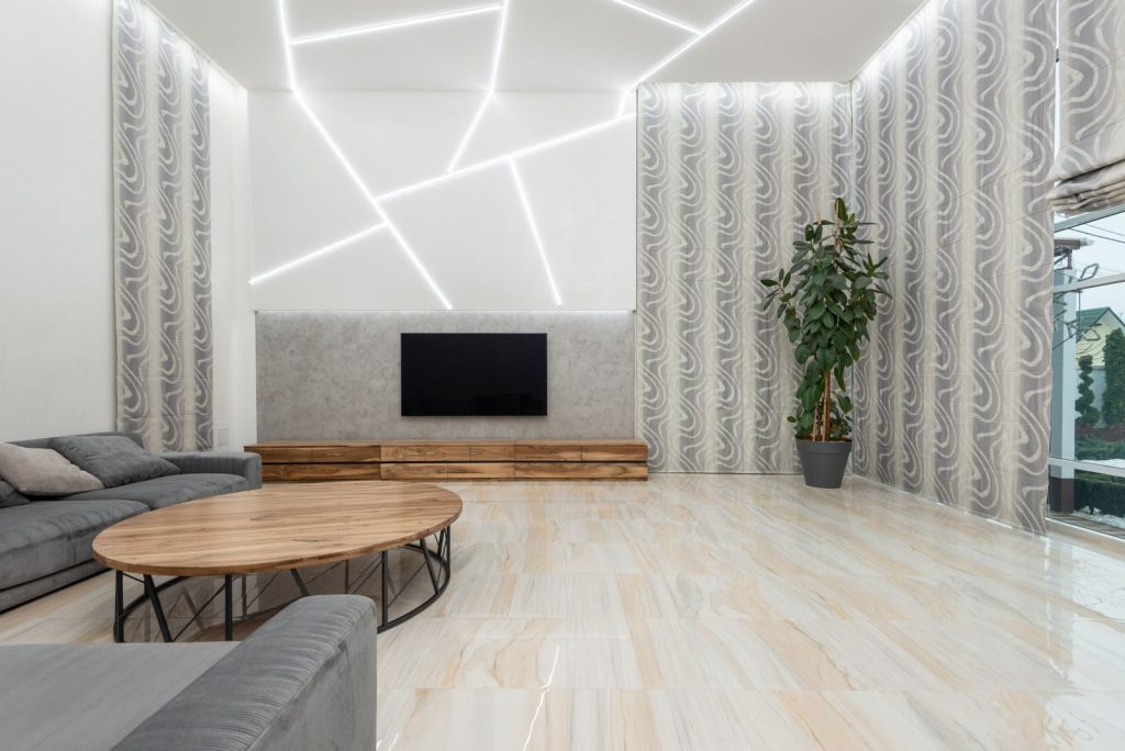 Interior of modern spacious light living room with comfortable sofa and wooden furniture