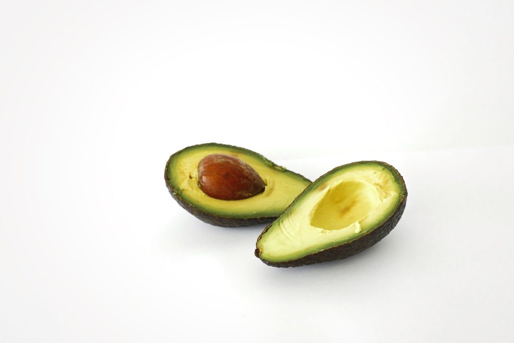 A studio shot of a ripe avocado sliced in half, showcasing its creamy texture.