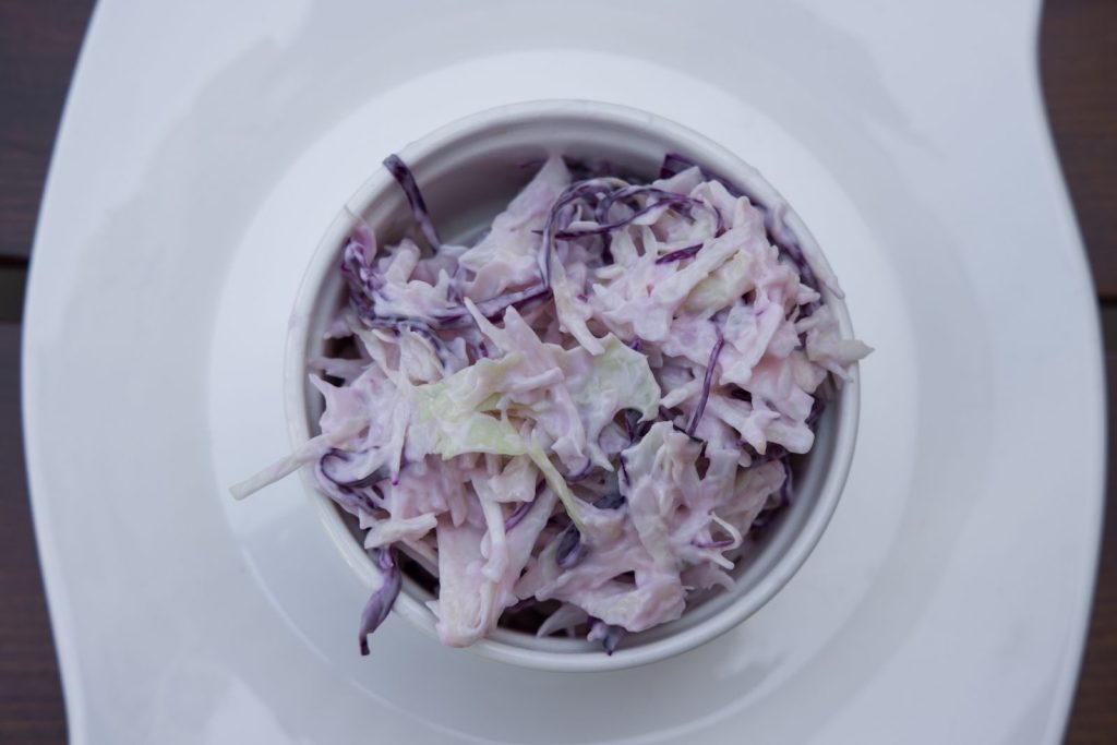 Delicious creamy coleslaw made with red cabbage in a white bowl, perfect for healthy, vegetarian meals.