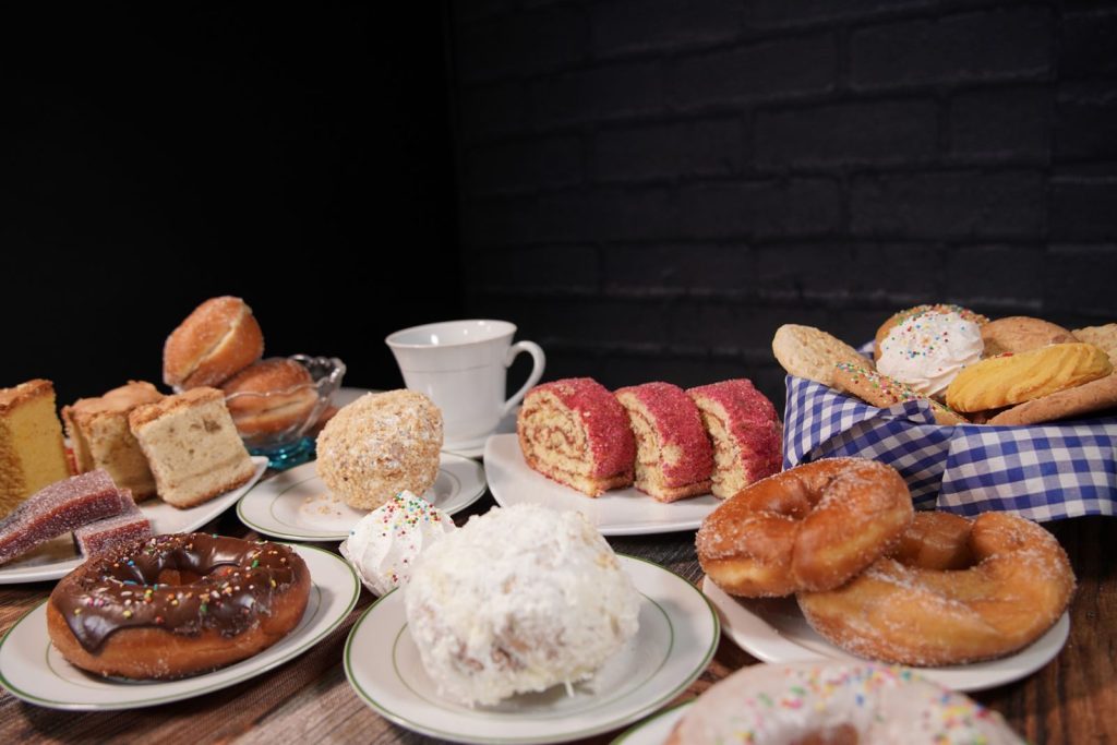 A delectable assortment of pastries and cakes on plates with a coffee mug, perfect for breakfast or dessert.