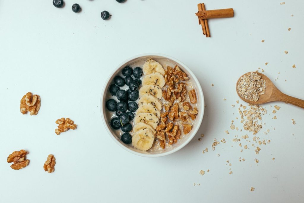 Delicious oatmeal topped with banana, blueberries, walnuts, and chia seeds in a bowl.