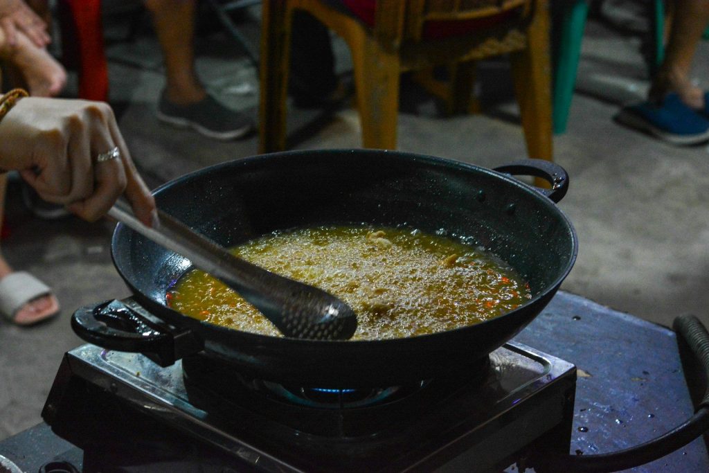 A woman stirring a pot of food on top of a stove
