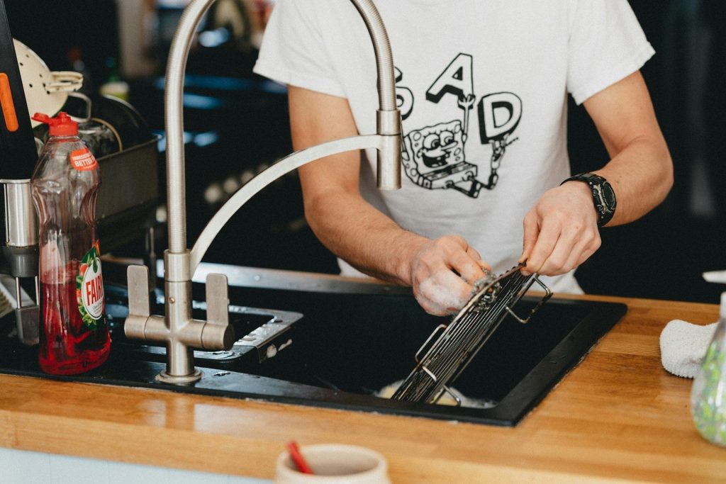 person in white crew neck t-shirt holding black and silver machine