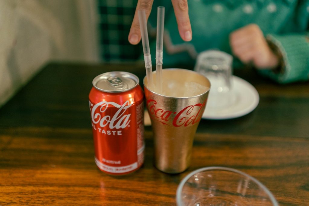 a person reaching for a can of coca cola