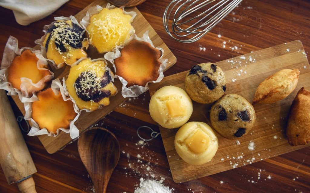 A delicious assortment of muffins and pastries displayed on wooden boards for a rustic food photography look.