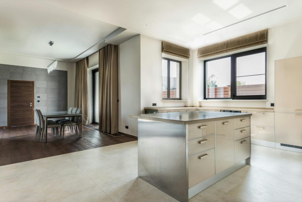 Spacious modern kitchen with minimalist design featuring sleek cabinetry and open dining area.