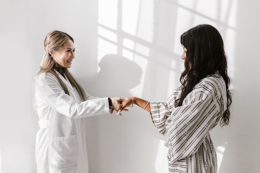 A friendly consultation between a doctor and patient in a bright, white room setting.