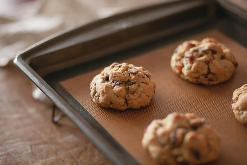 Warm cookies on a baking tray, showcasing fresh homemade dessert perfection.