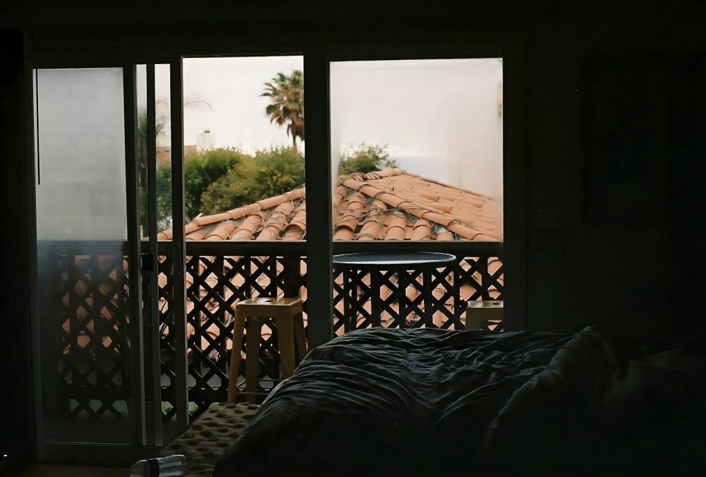 a bedroom with a view of the roof of a house