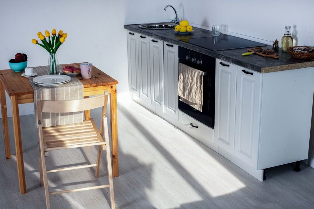 A bright and cozy kitchen featuring wooden furniture and kitchen essentials.