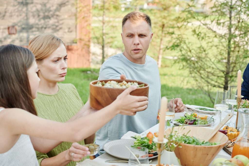 A family sharing a meal outdoors, showcasing togetherness and nature.