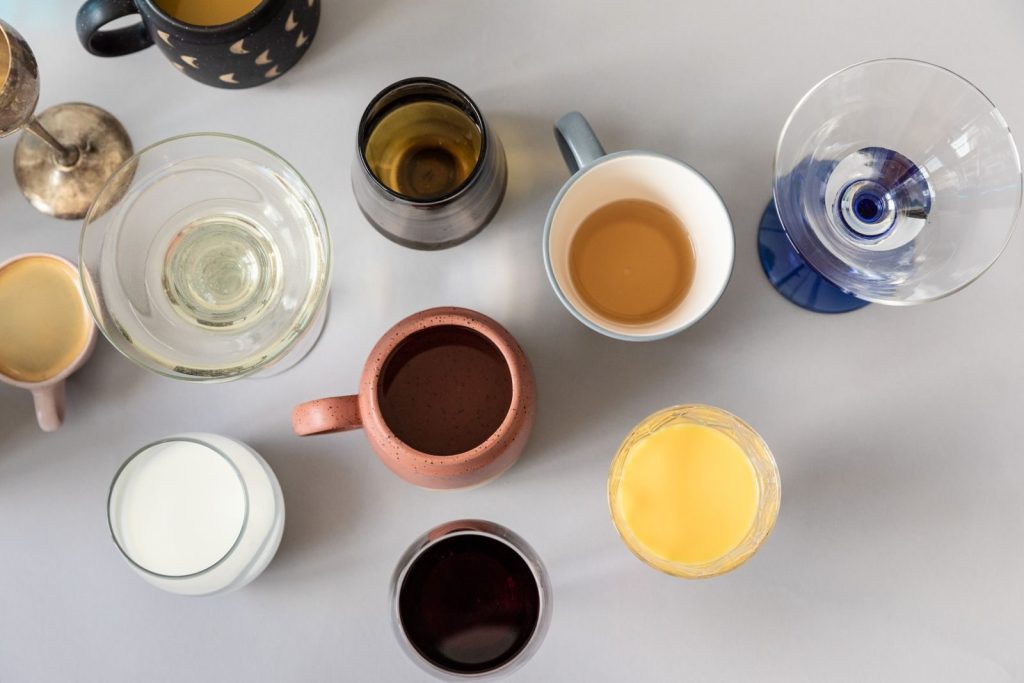 Diverse assortment of drinks in various containers captured from above, showcasing a variety of textures and colors.