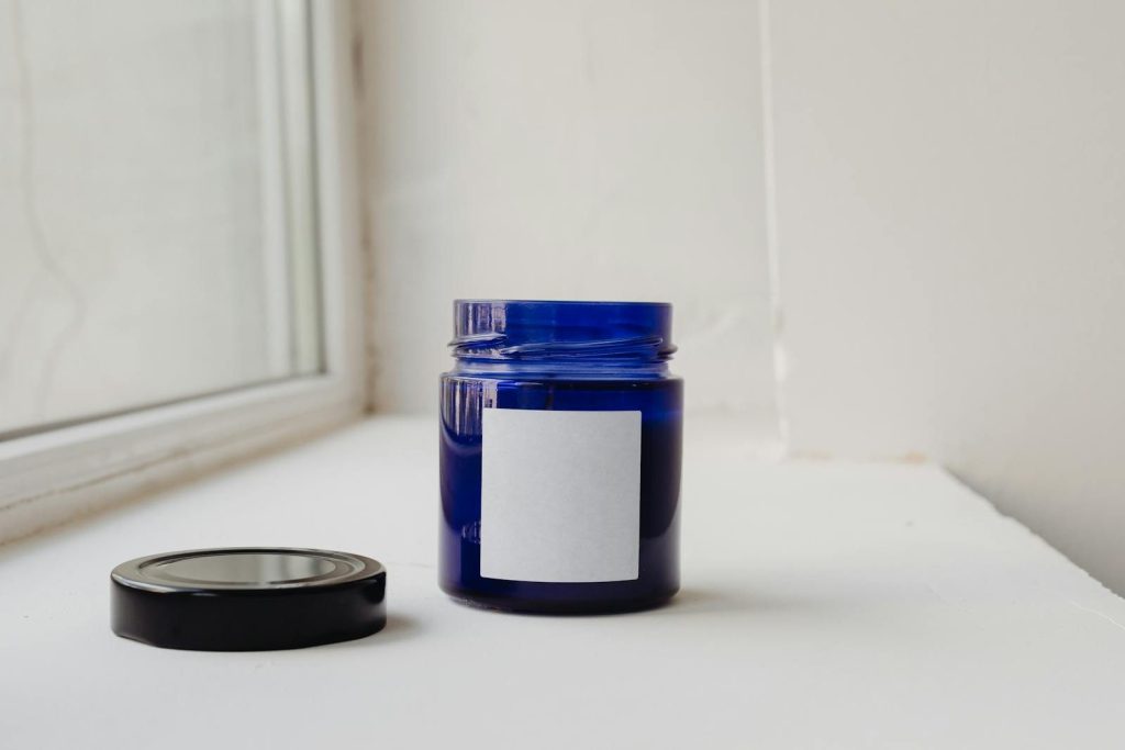 Minimalist shot of a blue glass jar with a blank label, perfect for branding or packaging concepts.