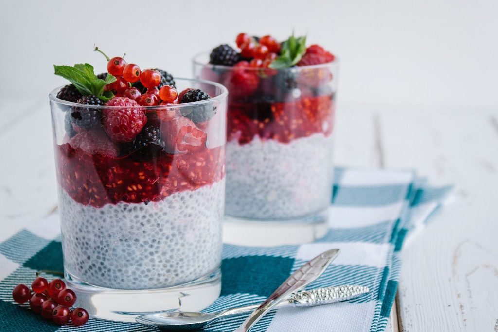Delicious chia pudding topped with fresh berries and mint on a checkered napkin.