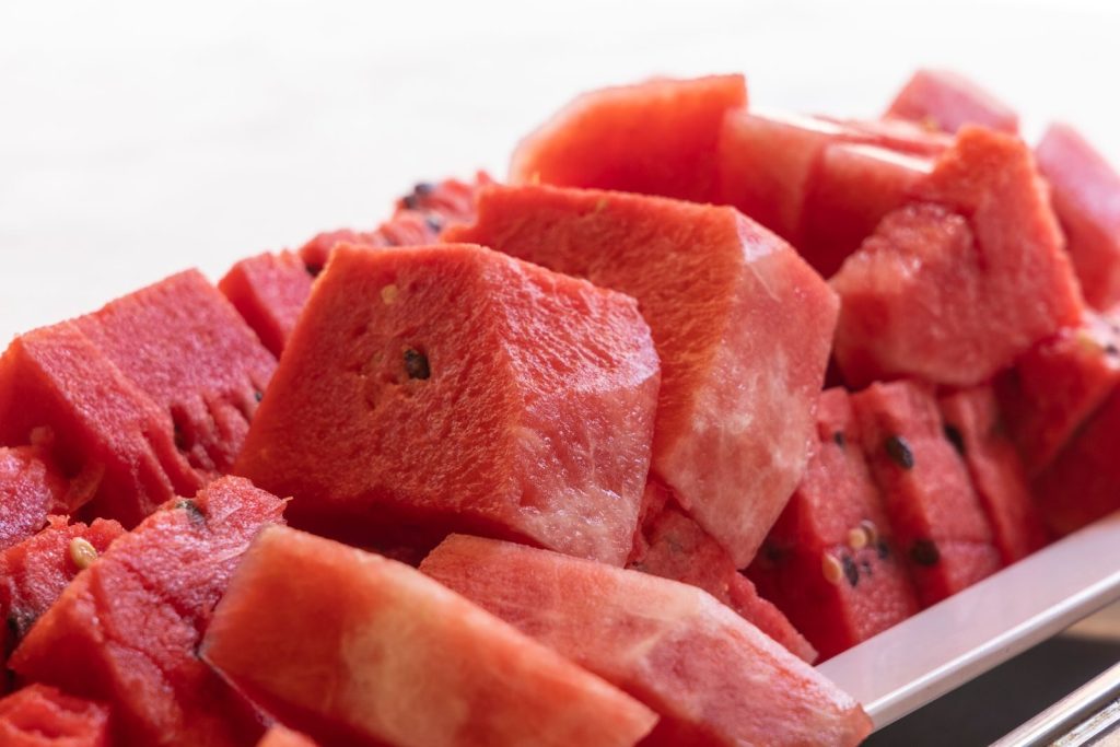 Close-up view of fresh sliced watermelon on a plate, highlighting its vibrant red color and freshness.