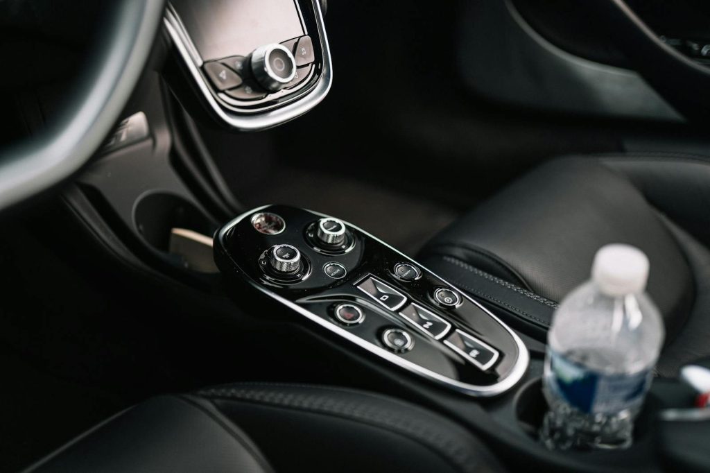 Close-up of a luxury car's high-tech control panel and dashboard, highlighting sleek design.
