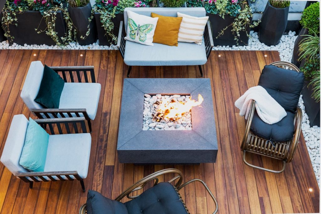A top-down view of a modern patio featuring stylish furniture and a central firepit.