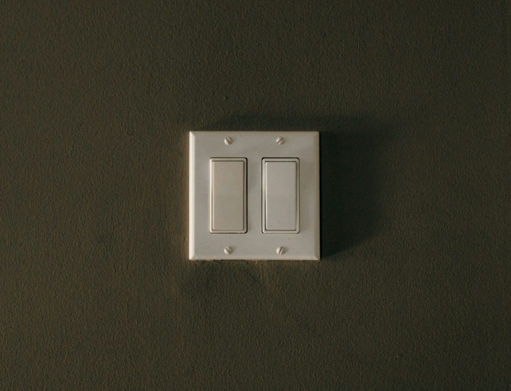 a white light switch sitting on top of a wall