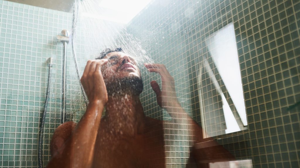 Theres nothing like a rejuvenating shower. Cropped shot of a handsome young man having a refreshing shower at home.