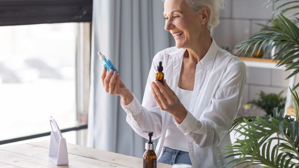 Beautiful senior woman doing beauty treatment procedures at home. Concept of skin care of mature females, anti-age cosmetics, beauty routine of elderly women. Serums for lifting