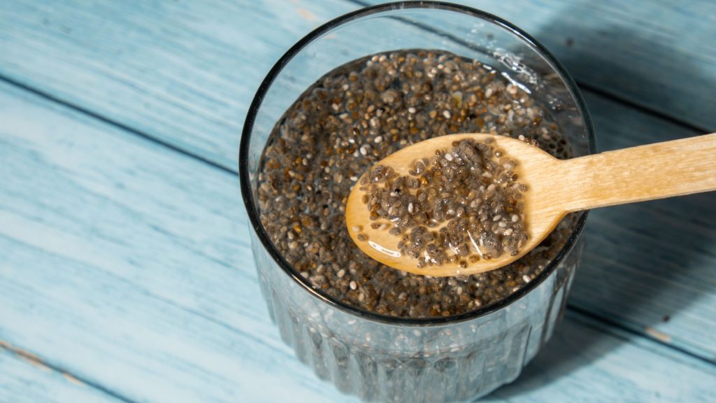 Preparing superfood water drink rich in Omega 3 fatty acids. Pouring coconut water. Adding soaked chia seeds and lemon detox Breakfast. Clean eating, weight loss, dieting food concept Vegetarian