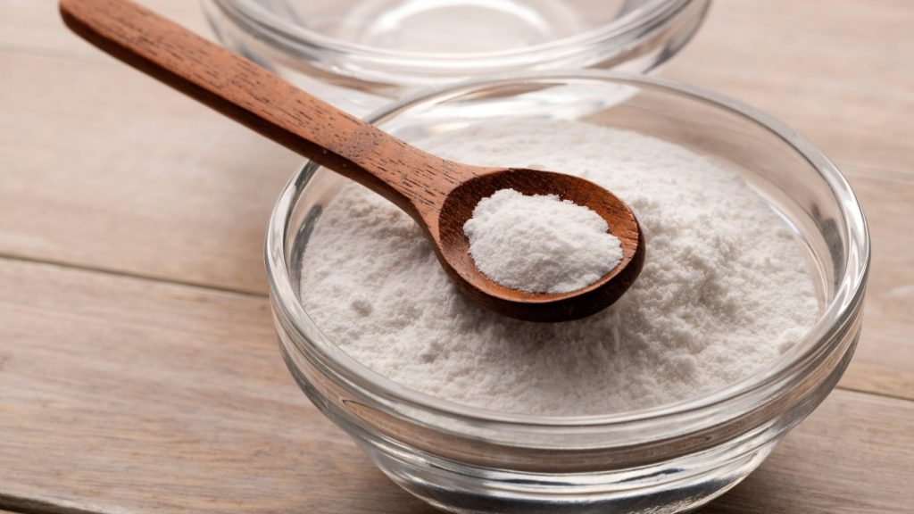 Baking soda powder in a spoon and bowl with mineral water - Healthy food
