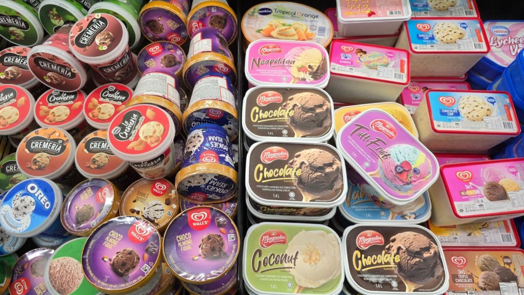 Bangsar, Malaysia – Mar 29, 2025: Top view of various branded ice cream tubs neatly arranged in a supermarket freezer, including Cremeria, Walls, Magnolia, and Nestle.