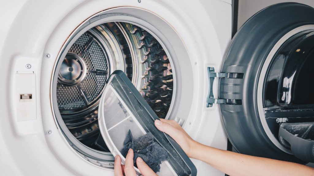 A Close-Up of a Person Removing Lint from  or Clothes Dryer Lint Trap, Showcasing the Essential Maintenance for Efficient Laundry Care