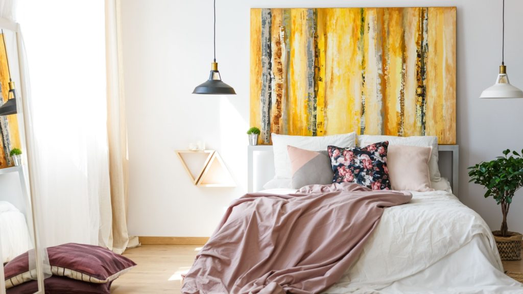 Yellow monochromatic painting above a big double bed