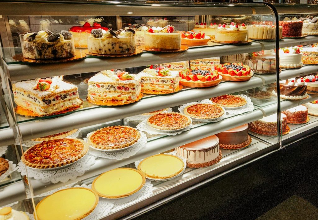 A display case filled with lots of cakes and pies