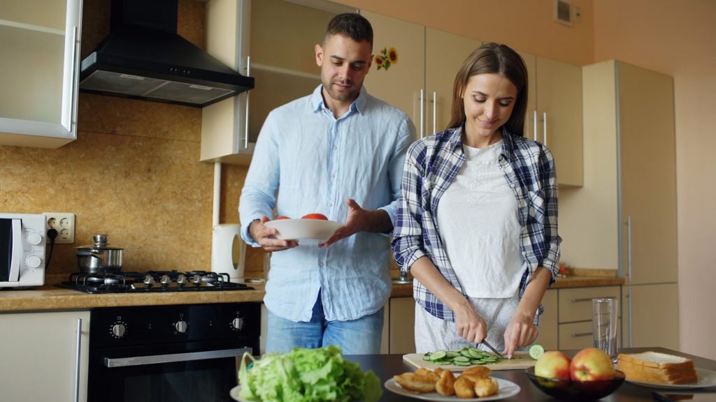 Couple preparing food together in a kitchen.