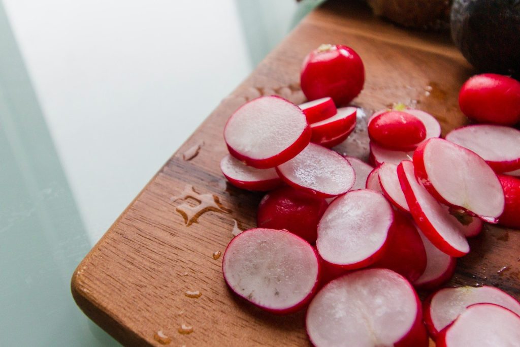 red and white round fruits on brown wooden chopping board