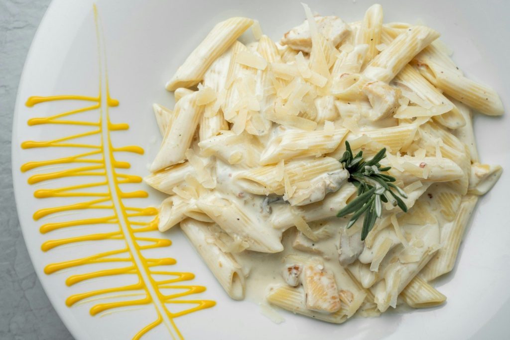 a white plate topped with pasta covered in sauce
