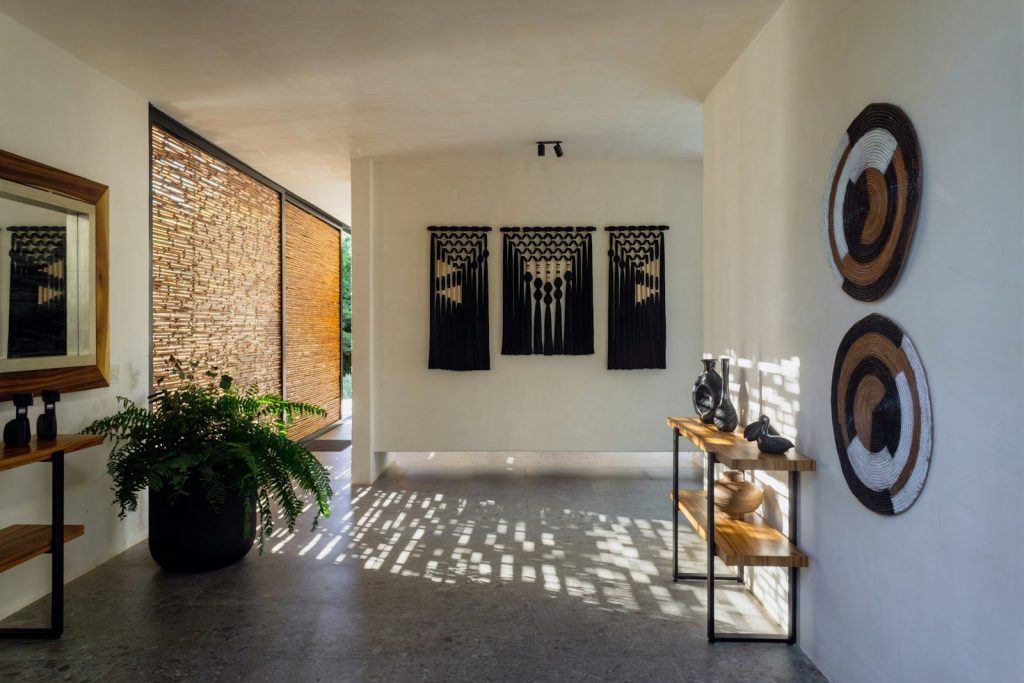 Modern hallway with decorative wall hangings and plants.