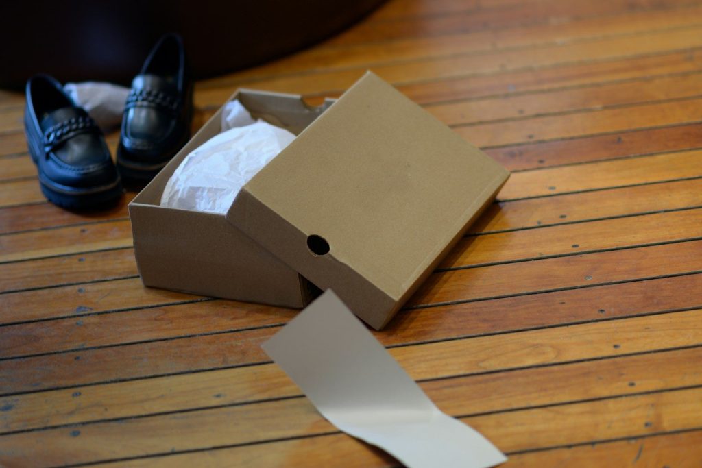 a pair of black shoes sitting on top of a wooden floor