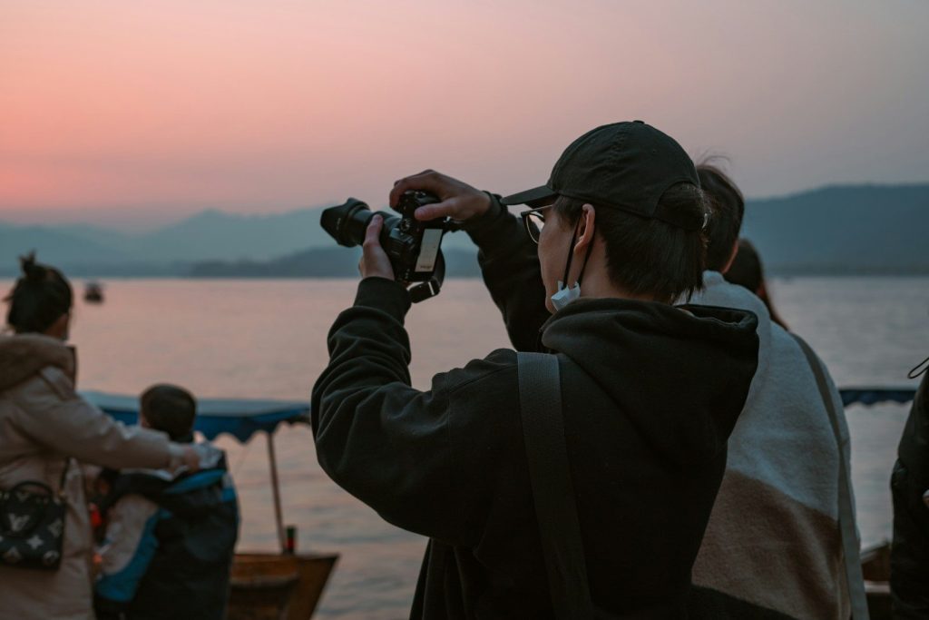 a man taking a picture of a sunset with a camera