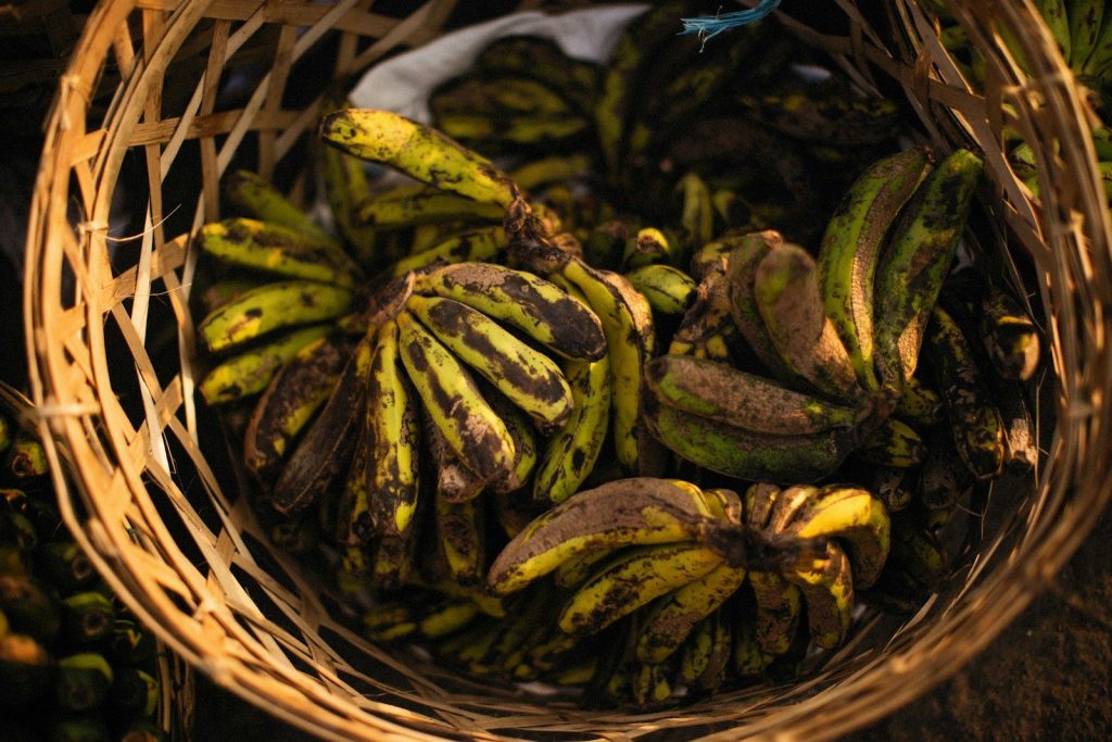 a basket filled with lots of green and yellow bananas
