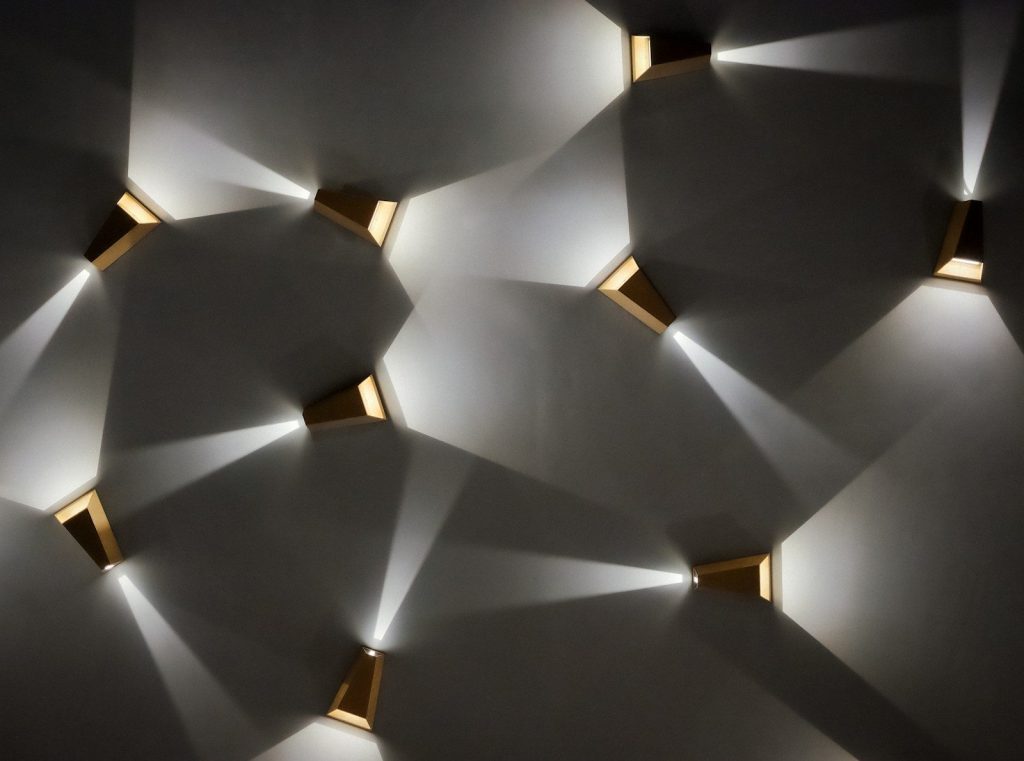Modern wall sconces casting light patterns on wall