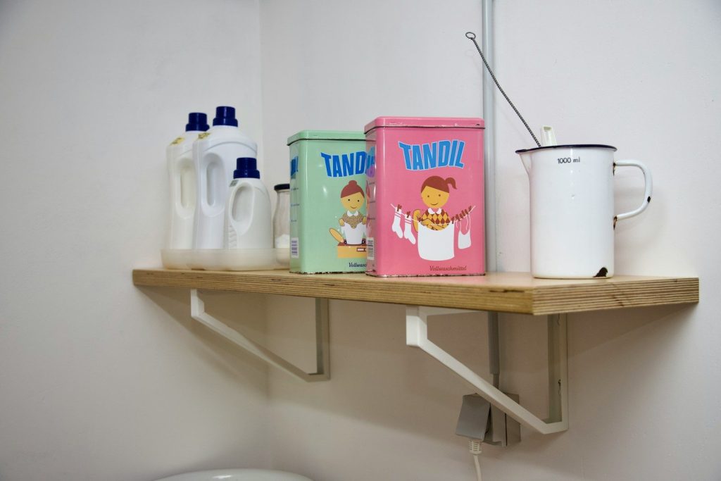 a shelf with a couple of tins on top of it