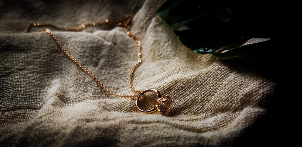 a pair of gold rings on a fabric surface