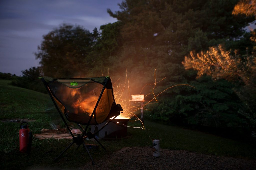 camper chair beside firepit beside trees